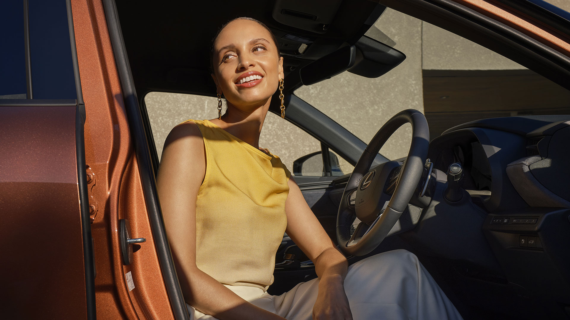Woman in yellow exiting a Lexus LBX